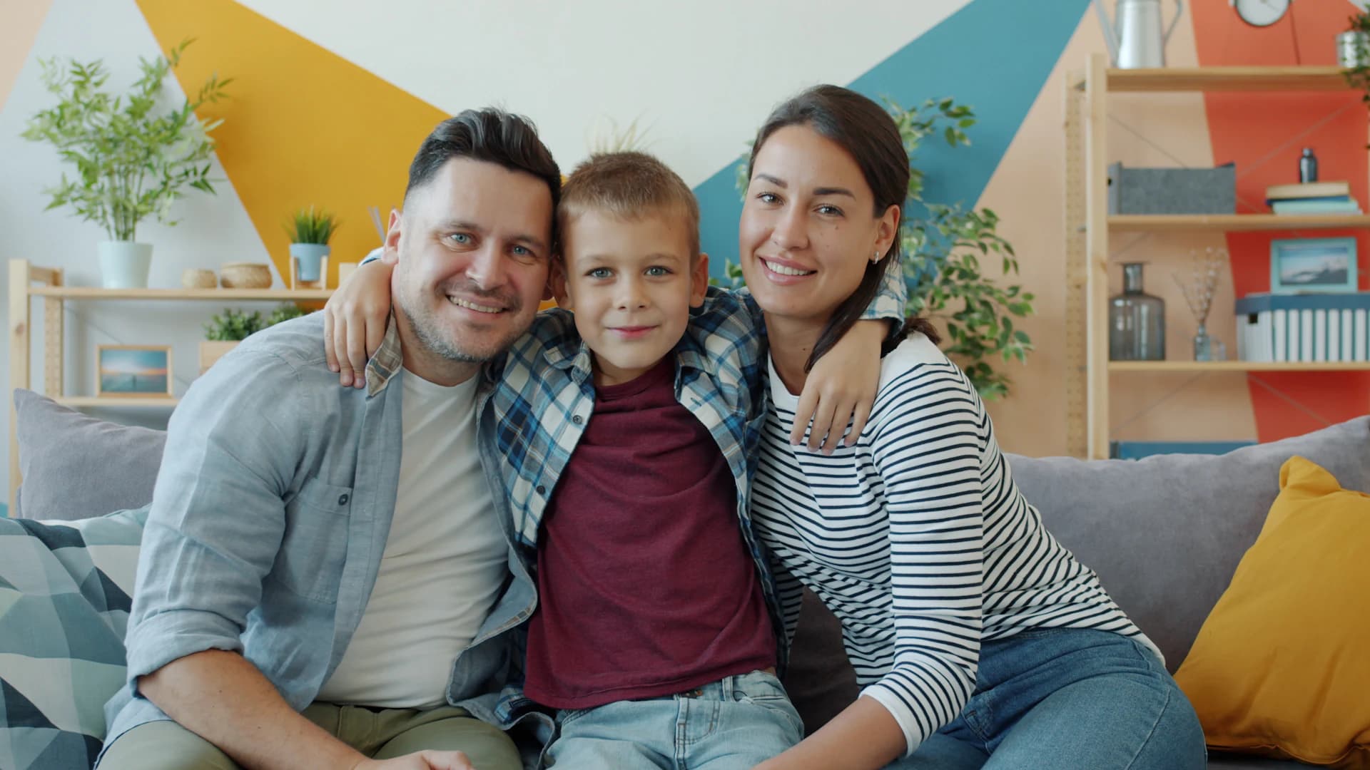 Família sorrindo junta no sofá da sala