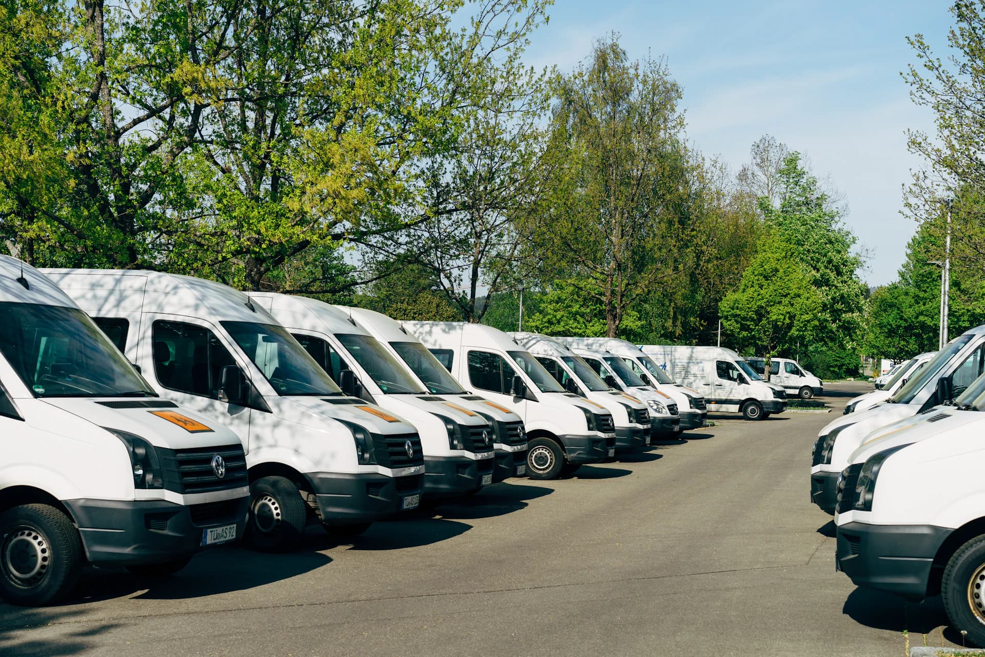 Fileira de vans brancas de uma frota empresarial estacionadas