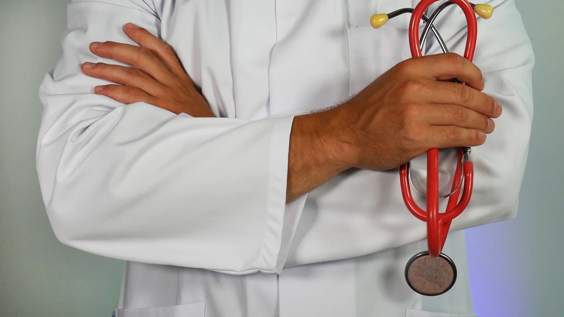 Médica de jaleco segurando um estetoscópio