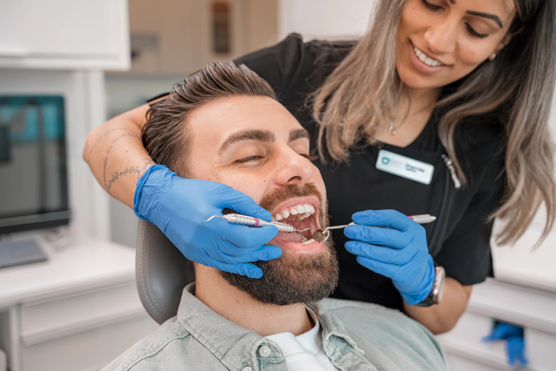 Dentista atendendo paciente sorridente no consultório